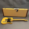 Vintage Fender Telecaster electric guitar with black pickguard and maple neck, displayed with tweed Fender hard case on gray background