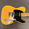 Vintage blonde electric guitar with black pickguard and two single-coil pickups on gray background