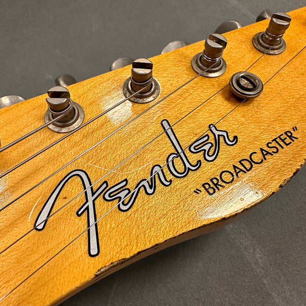 Close-up of Fender Broadcaster vintage guitar headstock with tuning pegs and worn yellow finish