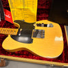 Vintage Fender Telecaster electric guitar in blonde finish with black pickguard, chrome hardware, and maple neck, displayed in a red velvet-lined hard case with original owner's manual and certificate.