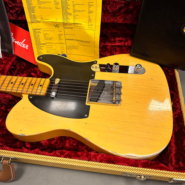 Vintage Fender Telecaster electric guitar in blonde finish with black pickguard, chrome hardware, and maple neck, displayed in a red velvet-lined hard case with original owner's manual and certificate.