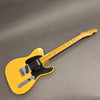 Vintage Fender Telecaster electric guitar with butterscotch blonde finish and black pickguard on gray background