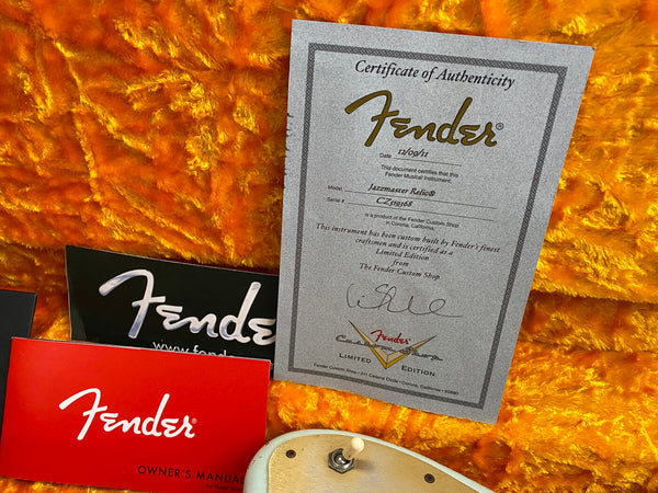 Fender Custom Shop Limited Edition Jazzmaster Relic certificate of authenticity with Fender owner's manual and black Fender card on orange plush background