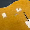 Close-up image of yellow guitar body with worn finish, visible cracks, and string ferrules, showing vintage wear and tear details.