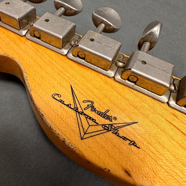 Close-up of vintage Fender Custom Shop guitar headstock with tuning pegs and worn wood finish
