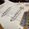 Close-up of vintage electric guitar white single-coil pickups, volume and tone control knobs, and bridge with metal saddles on sunburst body