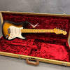 Fender Stratocaster electric guitar in sunburst finish with maple neck inside luxurious red velvet-lined vintage tweed hard case.