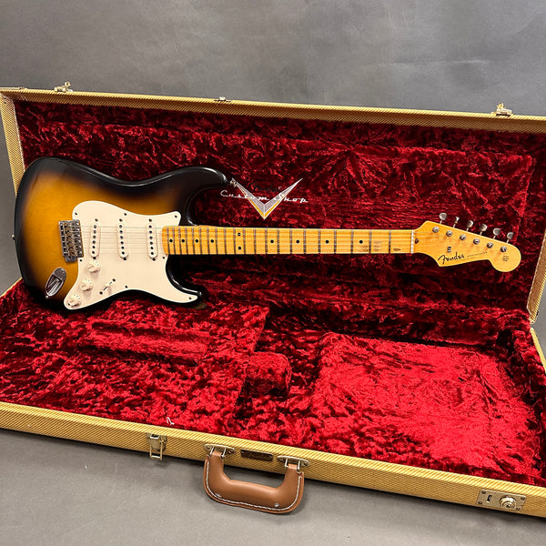 Fender Stratocaster electric guitar in sunburst finish with maple neck inside luxurious red velvet-lined vintage tweed hard case.