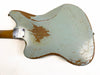 Back view of a vintage electric guitar with worn light blue finish and exposed wood, showing scratches and paint chips, featuring a bolt-on neck plate on a white background