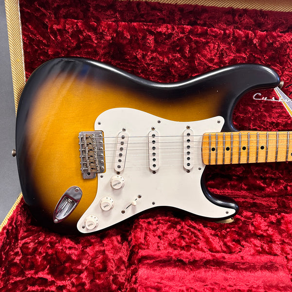 Vintage sunburst electric guitar with white pickguard and maple fretboard in red plush-lined hard case