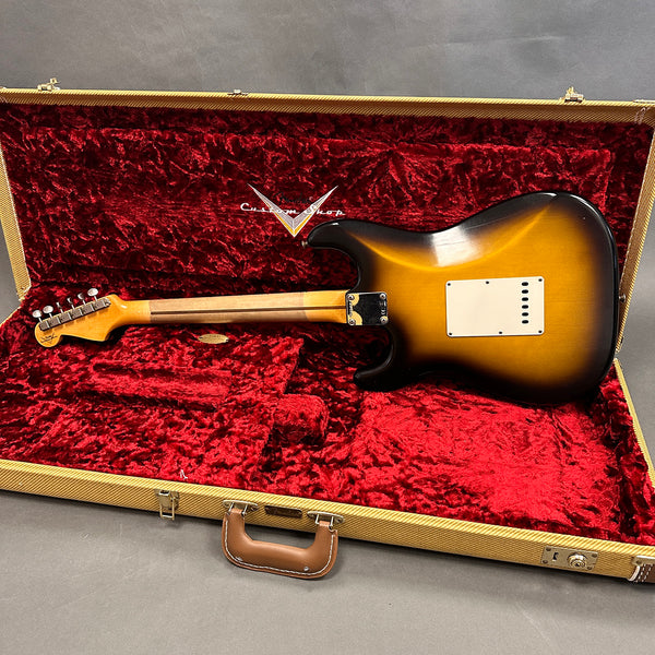 Fender Custom Shop electric guitar in sunburst finish inside open vintage tweed case with red plush interior showing back of guitar body and neck