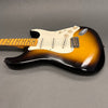 Vintage sunburst electric guitar with maple fretboard, three single-coil pickups, and white pickguard on gray background