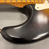 Close-up of black finish on electric guitar body showing wear and scratches near the neck and pickguard area