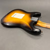 Sunburst finish electric guitar body with bolt-on maple neck and white backplate on grey background