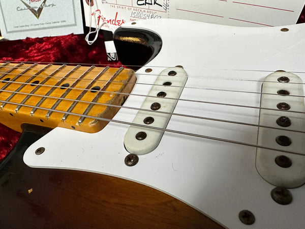 Close-up of vintage Fender Stratocaster electric guitar body and maple neck with single-coil pickups and white pickguard