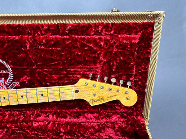 Close-up of Fender Stratocaster maple neck and headstock with vintage tuners in red velvet-lined guitar case