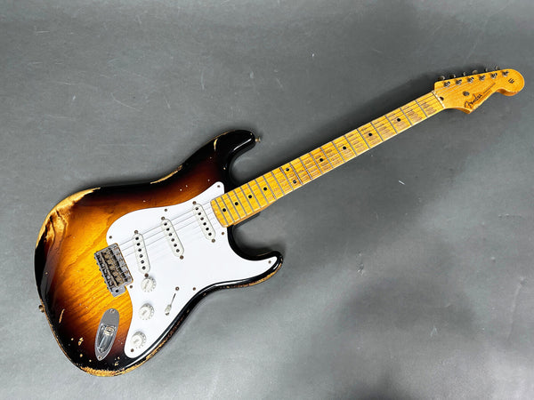 Vintage Fender Stratocaster electric guitar with sunburst finish and white pickguard showing worn and relic finish on body and maple neck