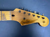 Close-up of vintage Fender Stratocaster guitar headstock with six tuning pegs and worn wood finish