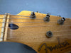 Close-up of vintage Fender guitar headstock showing tuning pegs, strings, and worn maple wood finish