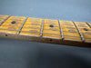 Close-up of worn maple guitar fretboard with metal frets and black dot inlays, vintage electric guitar neck detail