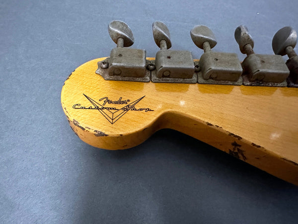 Close-up of vintage Fender Custom Shop guitar headstock with aged tuning pegs and worn wood finish