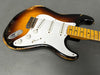 Vintage sunburst electric guitar with white pickguard and maple neck showing wear and aging on body and fretboard