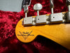 Close-up of Fender Custom Shop guitar headstock with vintage tuning machines on red plush guitar case lining