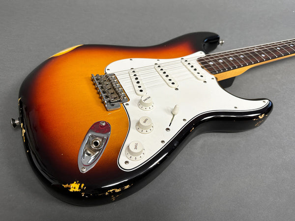 Electric guitar with sunburst finish and white pickguard showing vintage wear and scratches on body edges, close-up angle