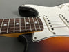 Close-up of sunburst electric guitar neck, fretboard, and white pickguard with single-coil pickups at Coffee House Guitars