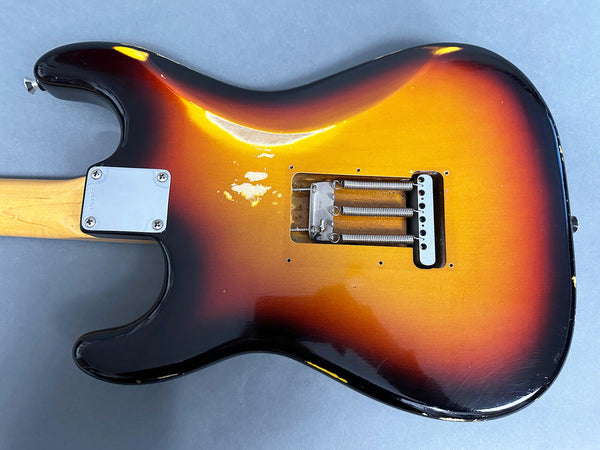 Vintage sunburst electric guitar body with missing backplate showing springs and tremolo cavity, worn finish with paint chips and scratches