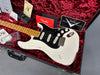 Vintage white Fender Stratocaster electric guitar with black pickguard and maple neck in red plush-lined hard case with Fender paperwork and accessories