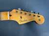 Close-up of Fender Stratocaster guitar headstock with vintage tuners and original contour body logo on natural wood finish