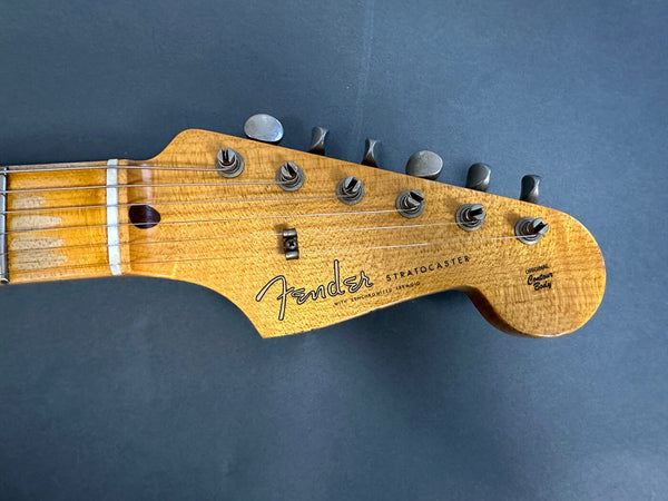 Close-up of Fender Stratocaster guitar headstock with vintage tuners and original contour body logo on natural wood finish