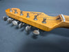 Close-up of vintage Fender Stratocaster maple guitar headstock with six tuning pegs and strings on gray background