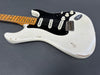 White vintage electric guitar with maple neck, black pickguard, three single-coil pickups, and worn finish showing natural wood beneath.