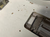 Close-up of worn, cracked white guitar body showing aging finish and metal bridge plate with springs on electric guitar