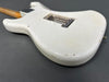 White vintage electric guitar body with aged wear and finish checking, close-up detailed view