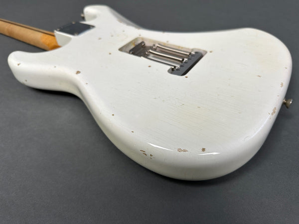 White vintage electric guitar body with aged wear and finish checking, close-up detailed view