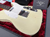Close-up of vintage white Fender Telecaster electric guitar body with single-coil pickups and aged finish inside red plush-lined hard case