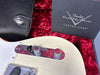 Close-up of vintage white Fender Telecaster electric guitar control plate with chrome knobs and switch, displayed with Fender Custom Shop Custom Care booklet on red plush case lining and black leather accessory pouch.