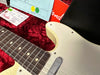 Close-up of vintage Fender Telecaster electric guitar body and fretboard inside red plush-lined hard case with Fender tag and documentation