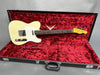 Vintage cream Fender Telecaster electric guitar in black hard shell case with red velvet interior lining, full view of body and neck.