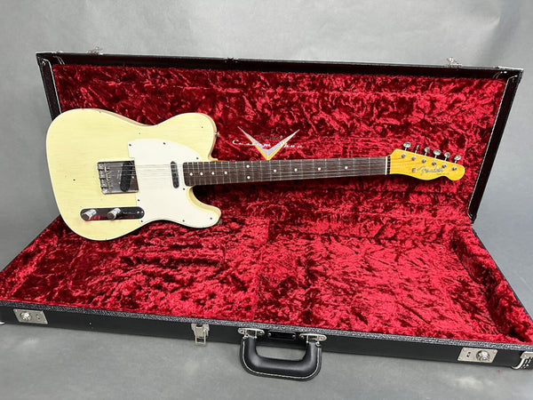 Vintage cream Fender Telecaster electric guitar in black hard shell case with red velvet interior lining, full view of body and neck.