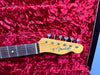 Fender Telecaster electric guitar headstock with six tuning pegs on red plush guitar case lining