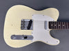 Vintage cream-colored electric guitar with white pickguard and rosewood fretboard on gray background