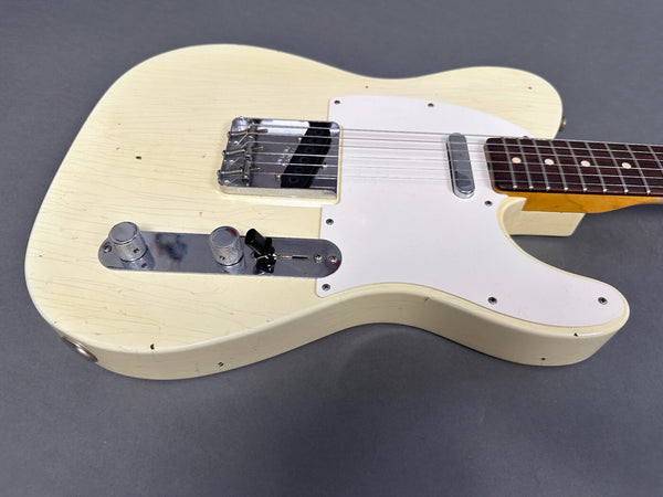 Vintage cream solid body electric guitar with white pickguard and chrome control plate on gray background