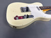 Vintage off-white electric guitar body with two chrome control knobs, single-coil pickups, white pickguard, and rosewood fretboard showing aging and wear details on a gray background