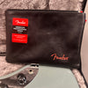 Fender American Professional Series Jaguar guitar accessory pouch with black leather texture and red Fender logo placed on light blue electric guitar in padded case