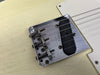 Close-up of Fender Telecaster vintage-style bridge with saddles and single-coil pickup on cream electric guitar body