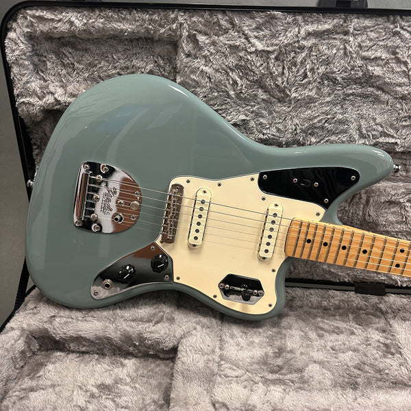 Seafoam green Fender Jaguar electric guitar with maple neck and white pickguard in a plush gray guitar case